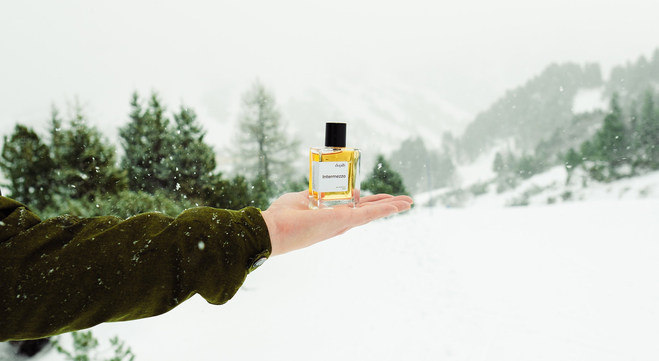 Parfum wird in Hand gehalten im Schnee